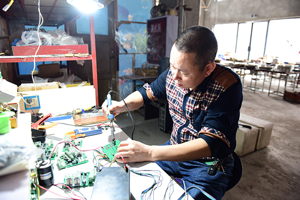彭朝继正在焊电路板。.JPG