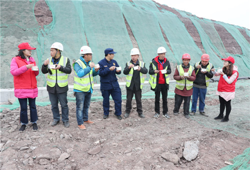 2月18日，在四川省广安市广安区中桥街道朝阳大道建设工地，消防指战员和青年志愿者正在与返工农民工一起品尝亲自包制、烹煮的“爱心汤圆”，让提前到岗的农民工过节不孤单.jpg