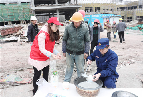 2月18日，在四川省广安市广安区中桥街道承平盛世三期建筑工地，青年志愿者和消防指战员正在给返工农民工舀亲自包制、烹煮的“爱心汤圆”，让提前到岗的农民工过节不孤单.jpg