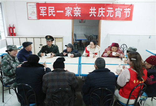 2月18日，在四川省广安市广安区浓洄敬老院，人武部官兵和党员志愿者正在与孤寡老人一起吃汤圆，共庆元宵佳节。.jpg