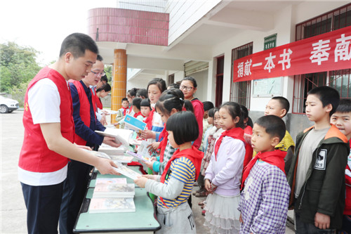4月22日，偏僻的广安市广安区肖溪镇竹山小学黄土村小，广安区民政局、税务局、政协文化文史和学习委的党员志愿者正在向留守娃赠送图书，以送精神营养餐方式庆祝“4.23”世界读书日.jpg