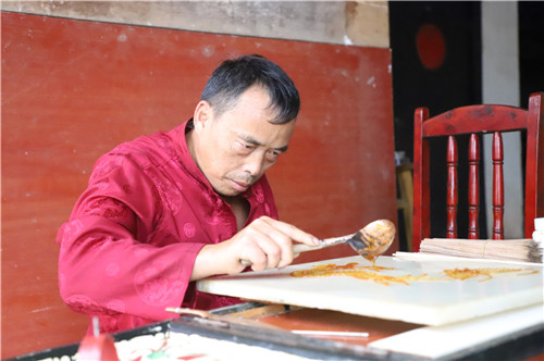黎明贵正在绘制糖画。.jpg