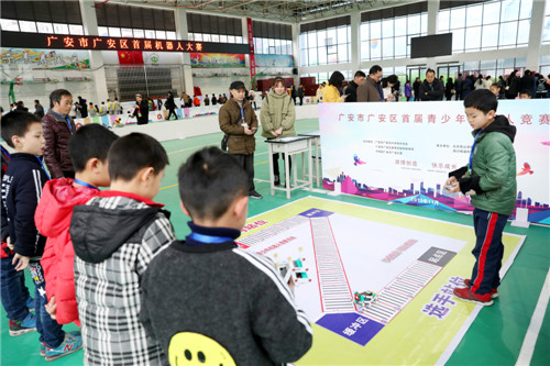 11月30日，在在北京景山学校四川广安实验学校体育馆内，广安区小学生在参加首届青少年机器人竞赛，一名小学生正在比拼机器人六足竞走.jpg