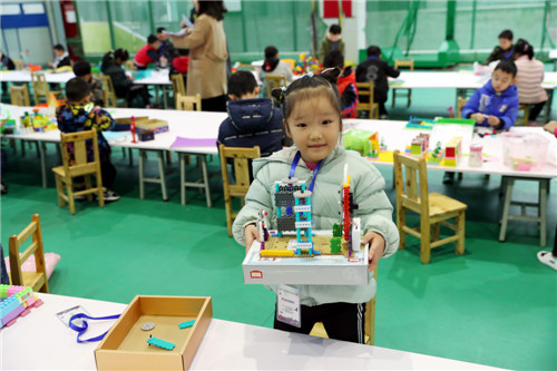 11月30日，在在北京景山学校四川广安实验学校体育馆内，广安区幼儿在参加首届青少年机器人竞赛，一名幼儿正在展示自己创意搭建作品.jpg