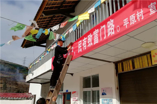 驻村援彝的王志辉 在村里上挂宣传标语.jpg