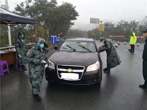 疫情防控体温监测点人员冒雨工作.jpg