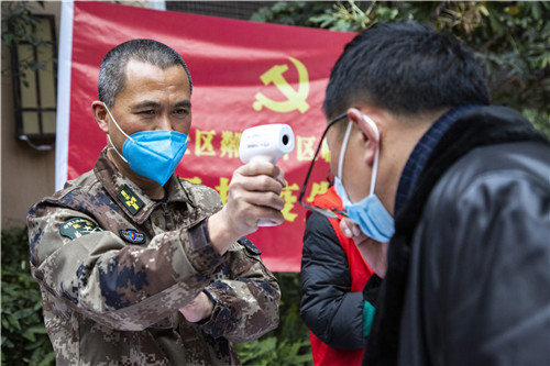 城东社区粼江片区临时党支部书记张华平为i群众测量体温。梁卫东 摄.jpg
