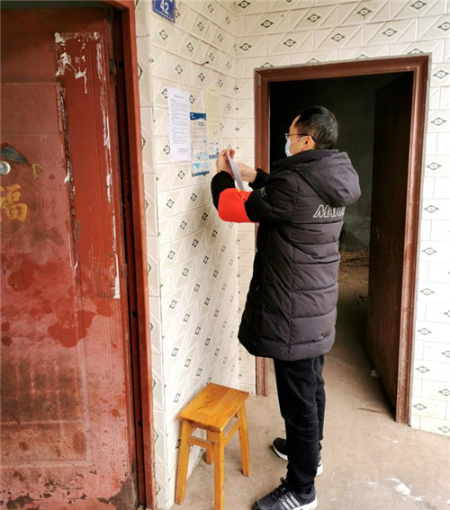 彭强正在入户张贴防控知识.jpg