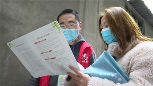 ▲县委组织部工作人员向志愿者发放宣传册.jpg