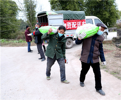图为村民在家门前买农用肥料和农用物质.jpg