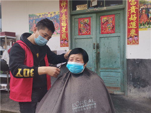 志愿者马建平为旷春英老人理发.jpg