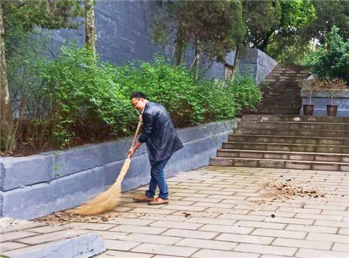 武胜县退役军人事务局副局长谢洪文正在打扫陵园的卫生.jpg