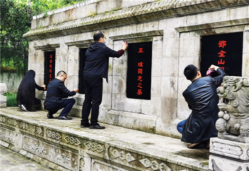 武胜县退役军人事务局干部职工正在清理烈士墓碑.jpg