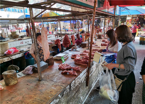 抽样监测人员在华蓥市农贸市场抽取猪肉样品.jpg