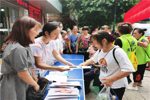 图为工作人员向群众发放宣传资料.jpg